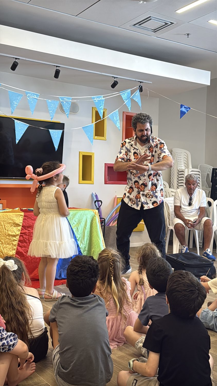 קהל של ילדים יושב על הרצפה וצופה במופע יום הולדת של איתמר המפוזר